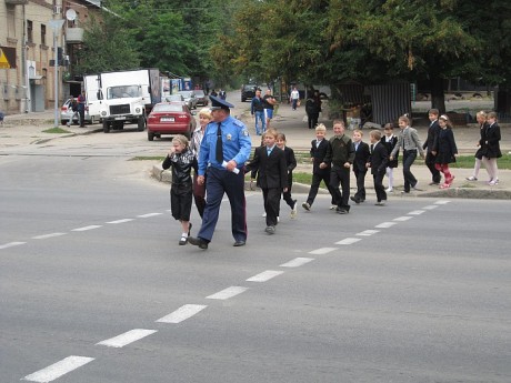 Сотрудник ГАИ переводит школьников через дорогу
