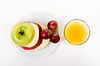 Яблоко, виноград на тарелку и стакан апельсинового сока | Фото