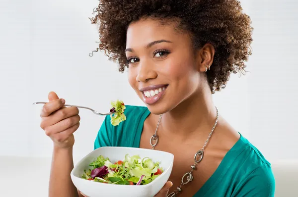 Афроамериканская женщина, едящая салат — стоковое фото