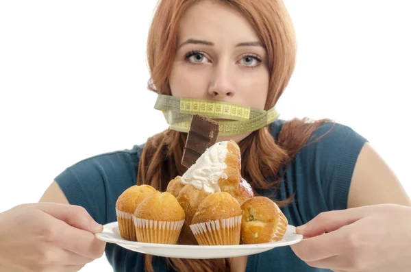 Женщина с сантиметр на ее рот, не в состоянии съесть все сладости и сахар, много печенья на тарелку. Диета без сладостей — стоковое фото