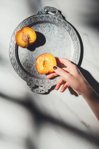 Cropped Shot Woman Holding Peach Piece Metal Tray Light Marble — стоковое фото