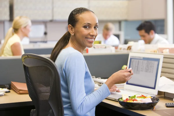 Бизнес-леди в кабине с ноутбуком, едят салат — стоковое фото