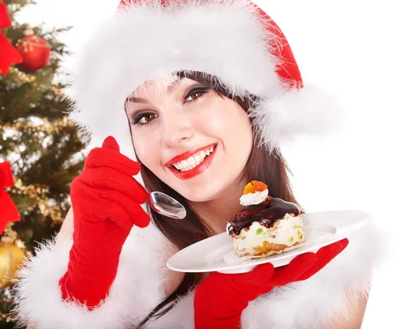 Рождество девушка в шляпе Санта съесть торт на тарелку — стоковое фото